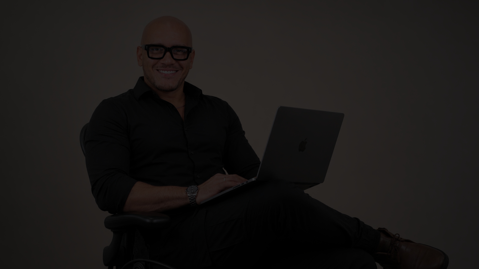 Oneill Fermin, estratega de marketing digital, sentado con su portátil